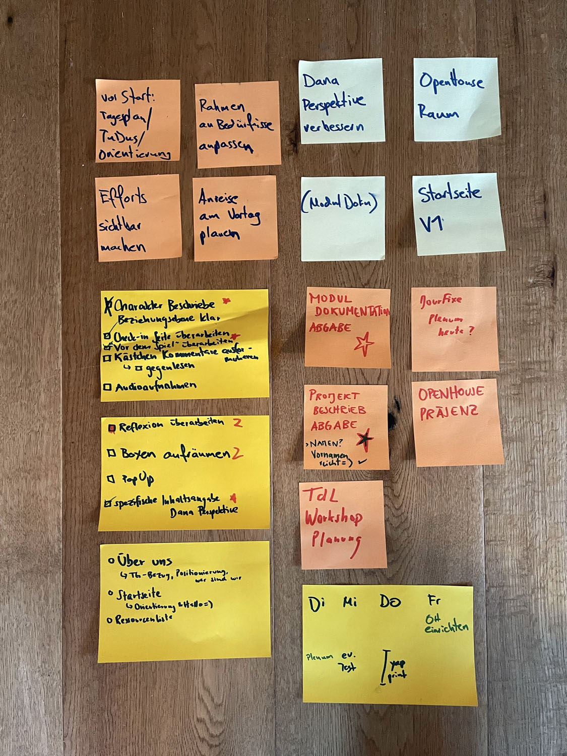 Sorgfältig angeordnete, farbcodierte Post-Its auf braunem, holzigem Hintergrund. Die Post-Its sind beschriftet mit To Do’s, Zielen und Wochenplanungen.